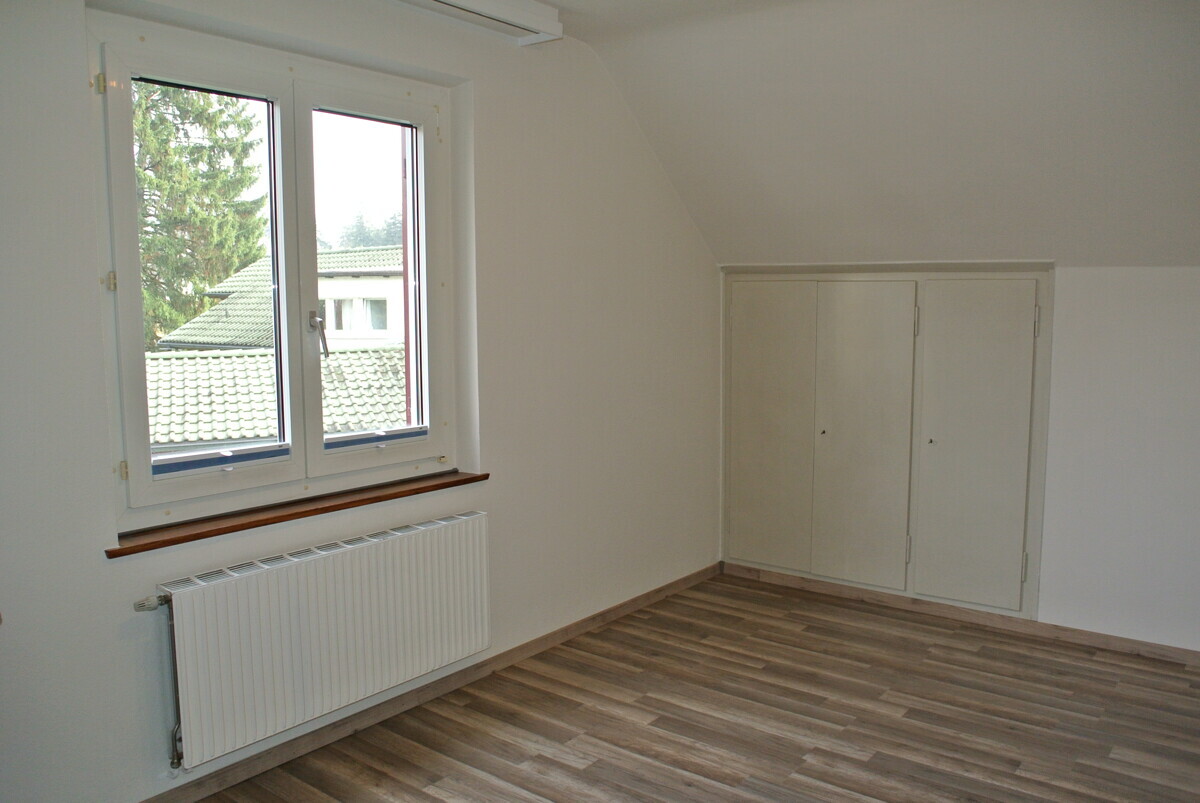 Helles Dachzimmer mit Fenster und Einbauschrank