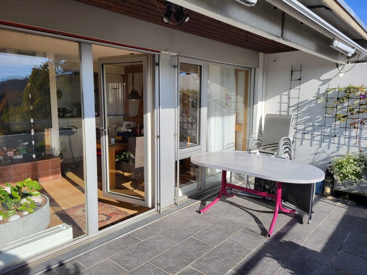 Sonnige Terrasse mit Schiebetüren