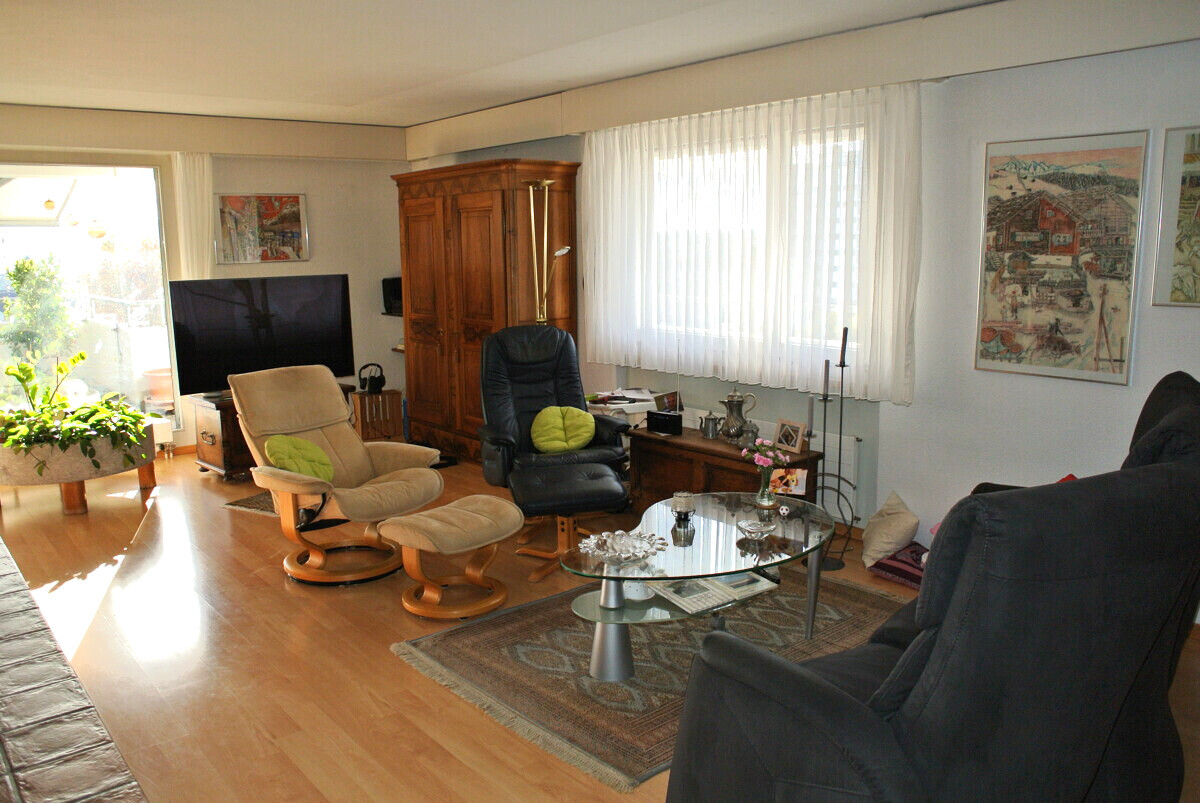 Helles Wohnzimmer mit mehreren Sesseln und großem Fenster