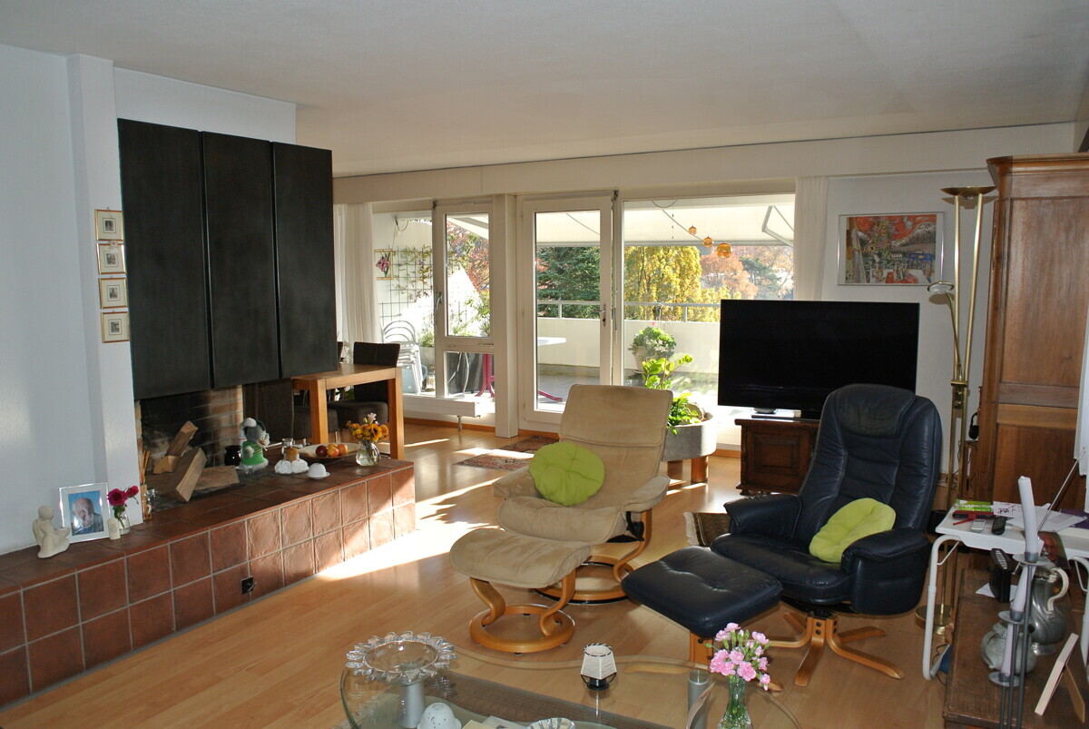Wohnzimmer mit Kamin und Terrassenzugang