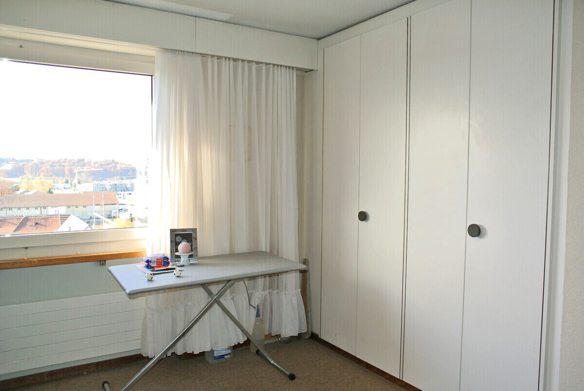 Helles Zimmer mit Einbauschränken und Fensterblick