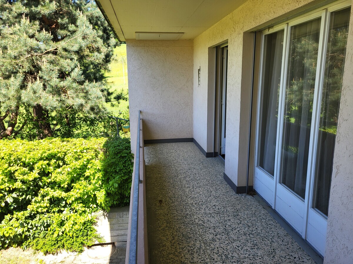Überdachter Balkon mit Blick ins Grüne