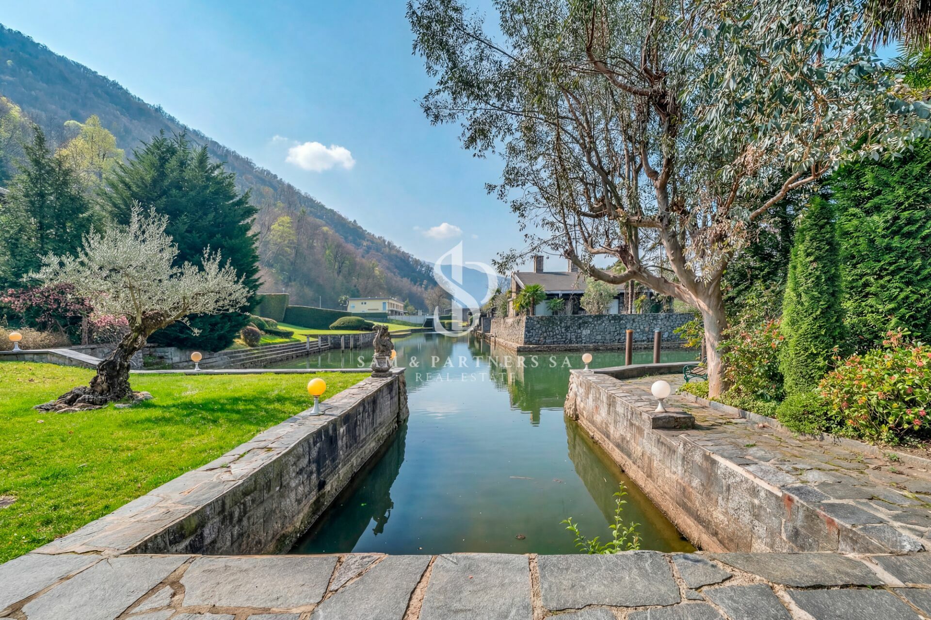 Landschaft mit Wasserkanal und Gartenanlage
