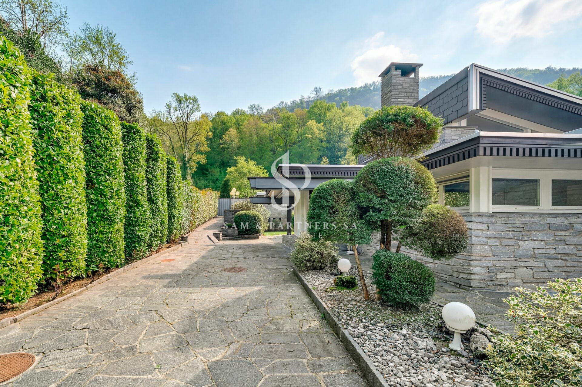 Außenansicht einer gepflegten Villa mit Gartenauffahrt