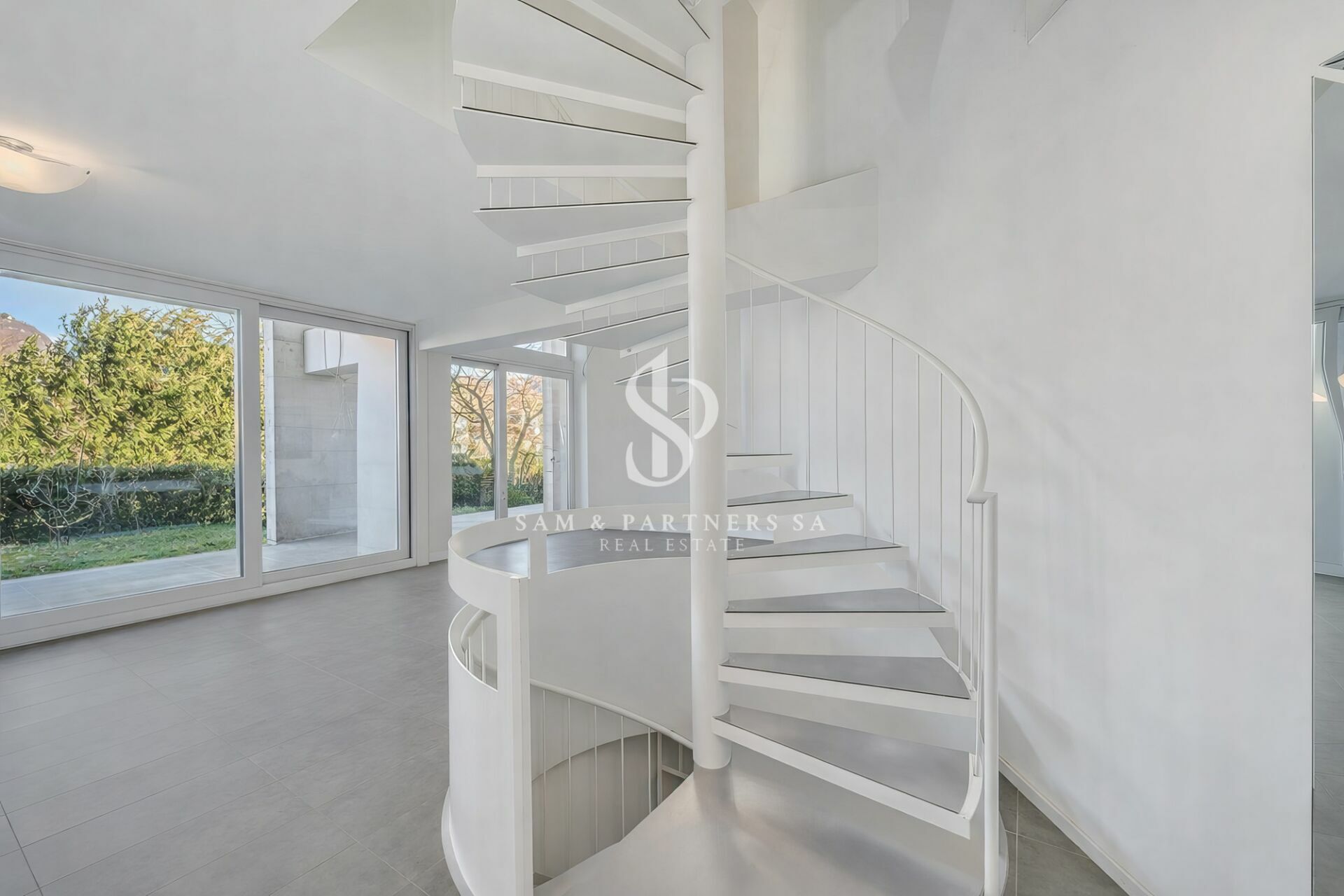Heller Wohnbereich mit weißer Wendeltreppe