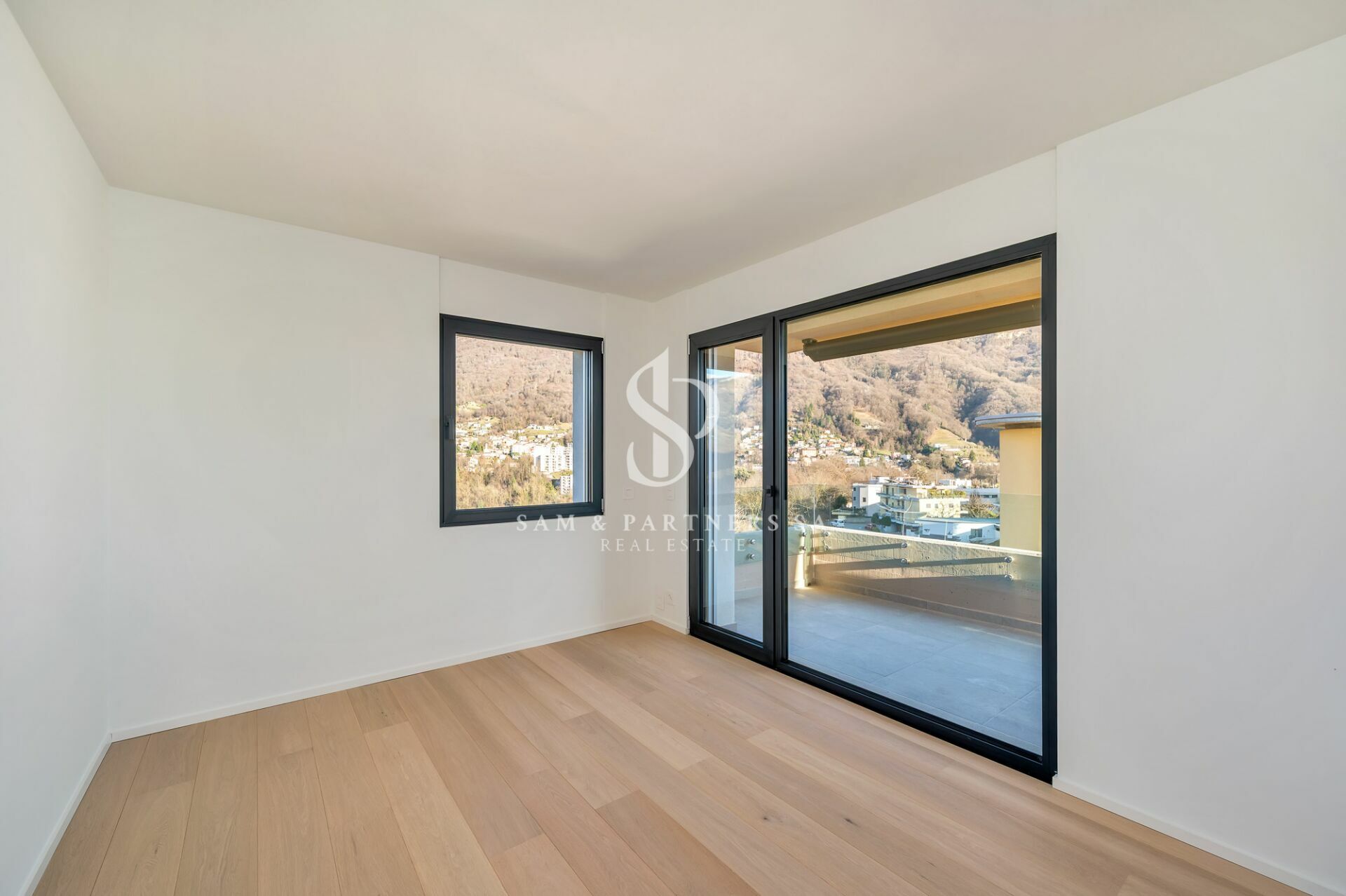 Heller, leerer Raum mit Balkon und Bergblick