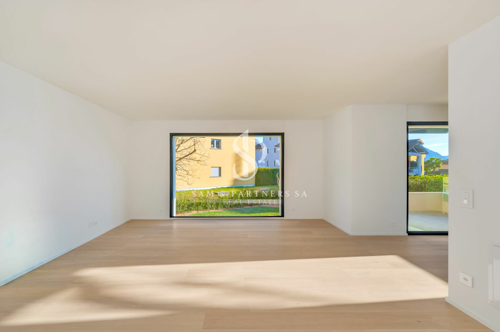 Heller, leerer Wohnraum mit Gartenblick