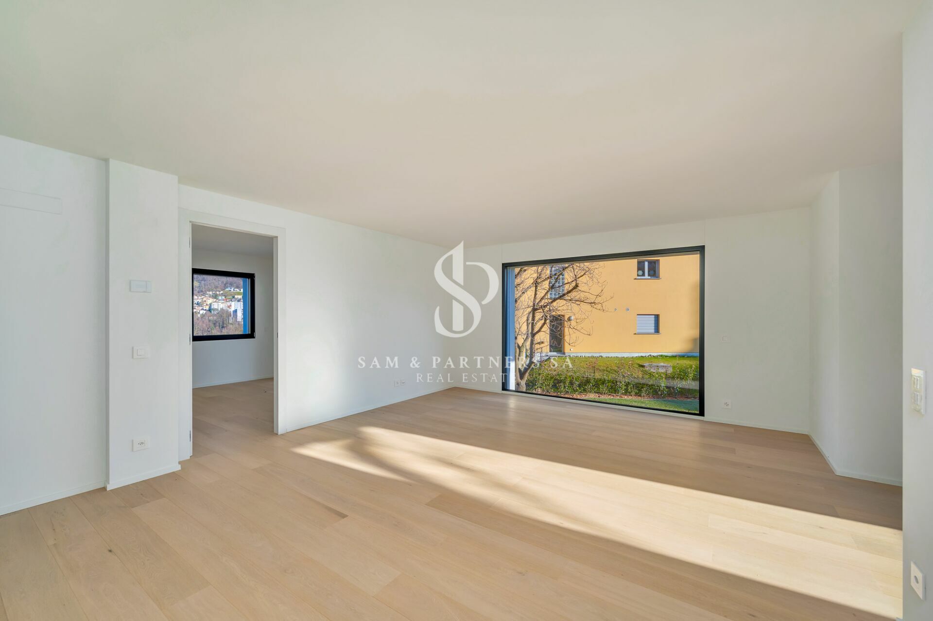 Heller, leerer Wohnraum mit großem Fenster