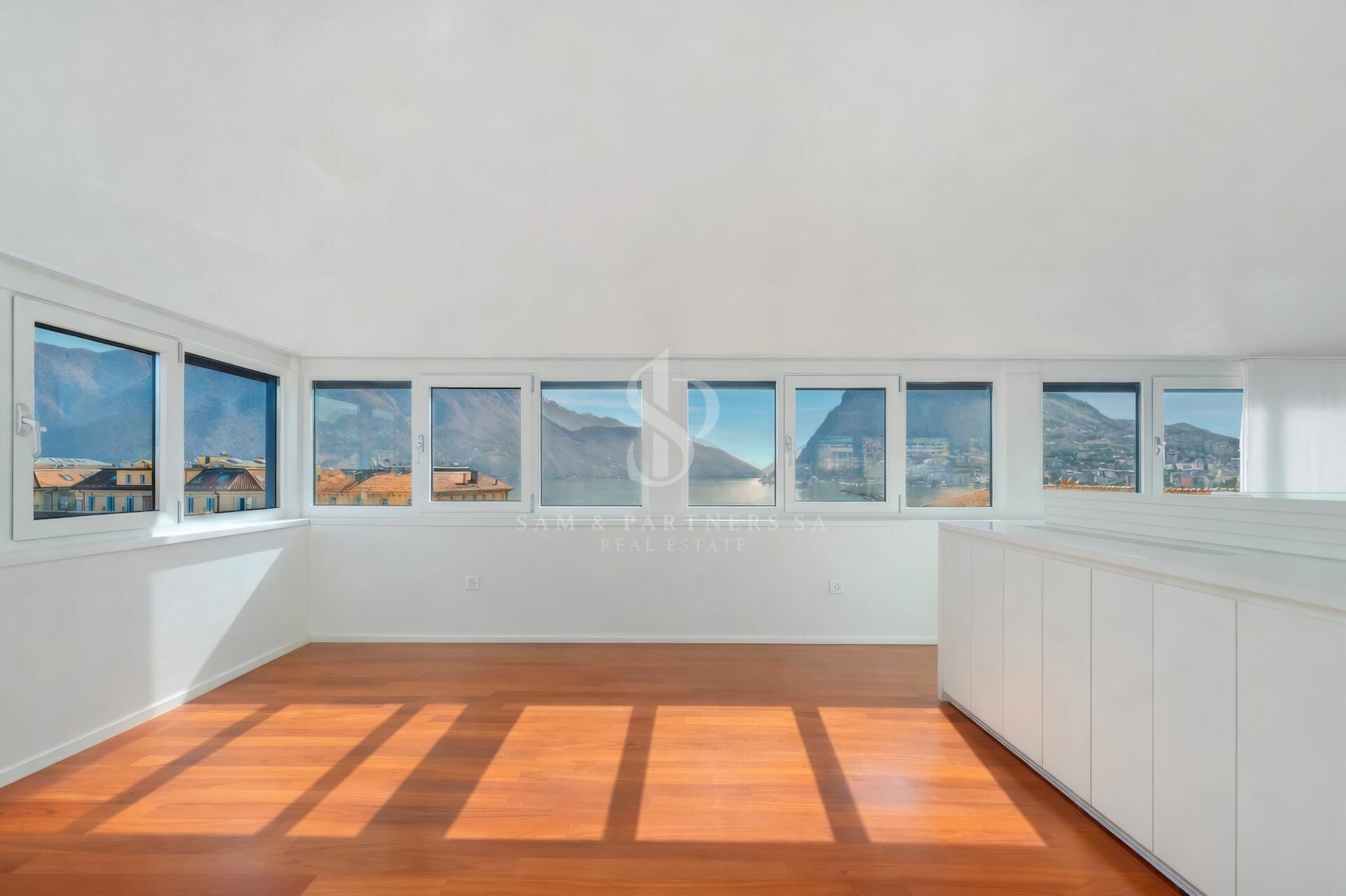 Heller Raum mit Panoramafenstern und Seeblick