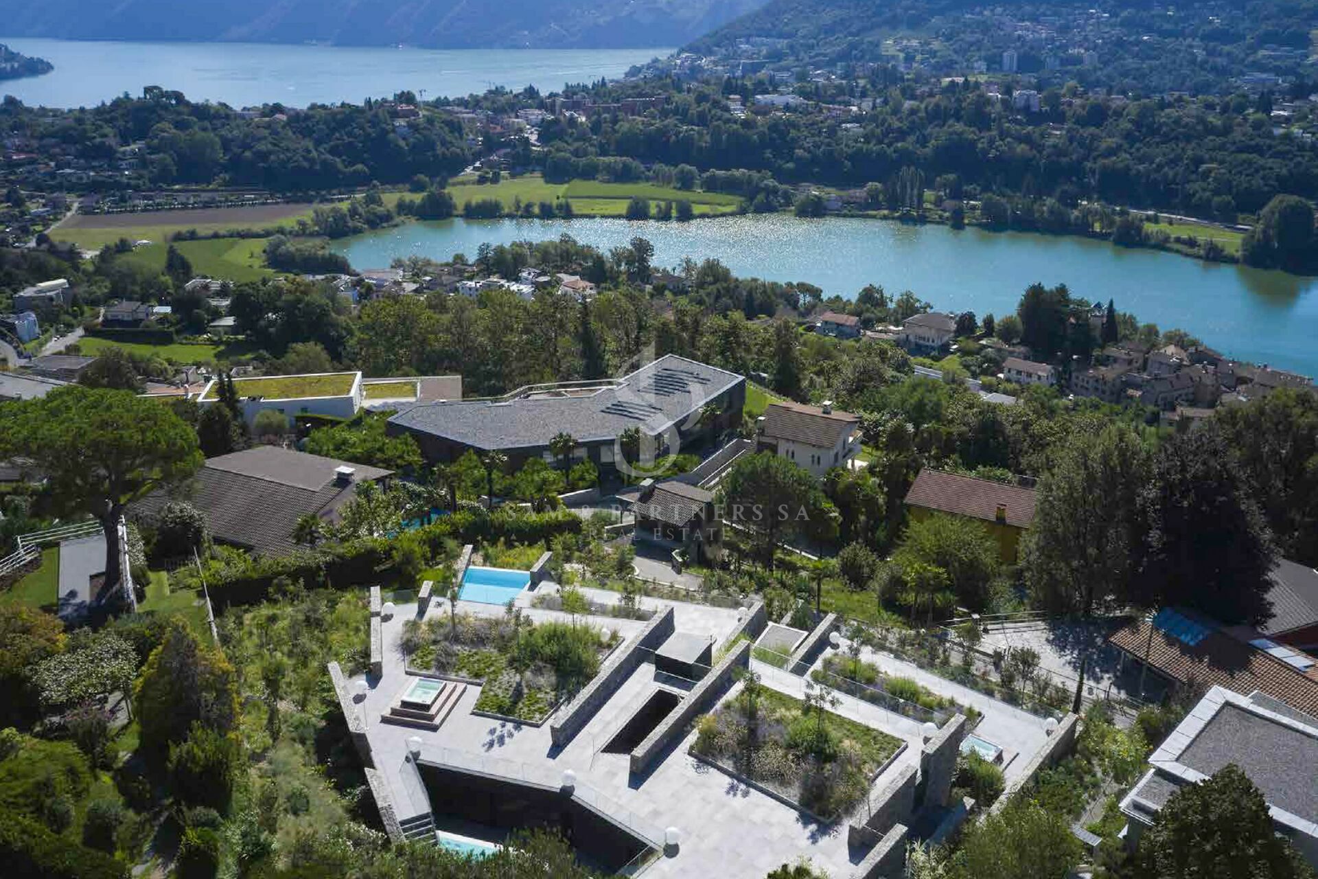 Luftaufnahme einer modernen Villa mit Pool und Seeblick