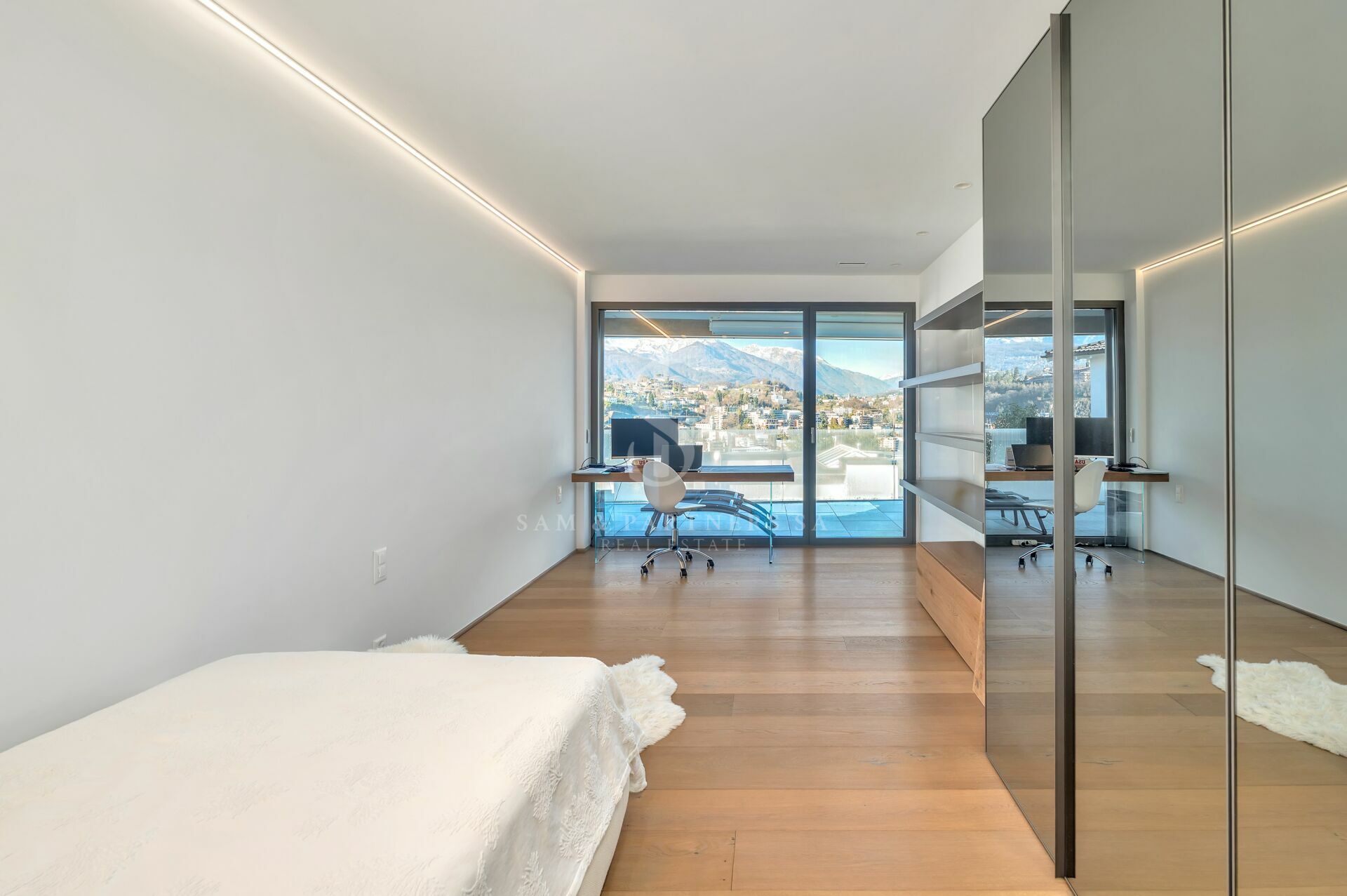 Modernes Schlafzimmer mit Arbeitsplatz und Bergblick