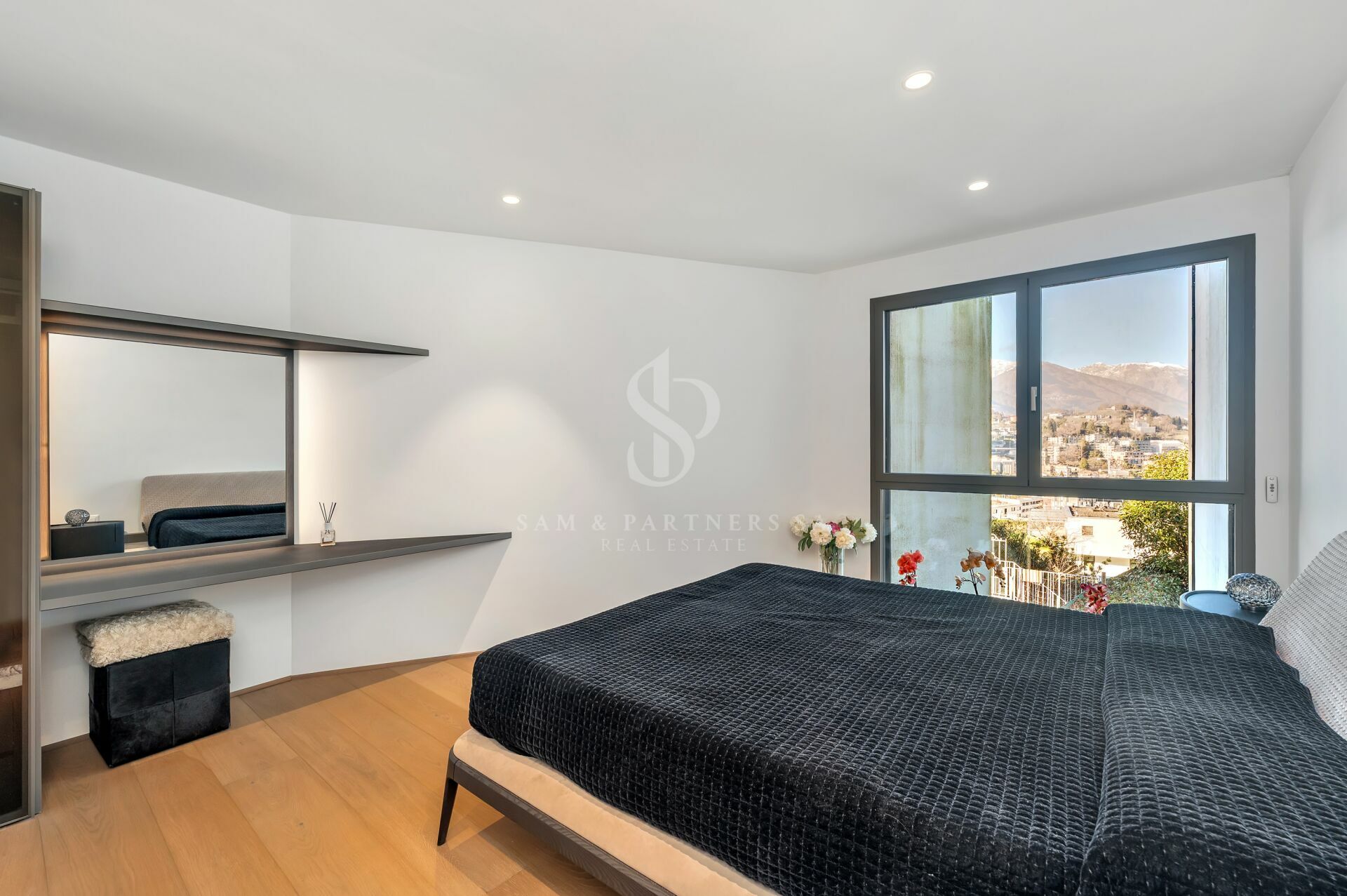 Modernes Schlafzimmer mit großem Fenster und Bergblick