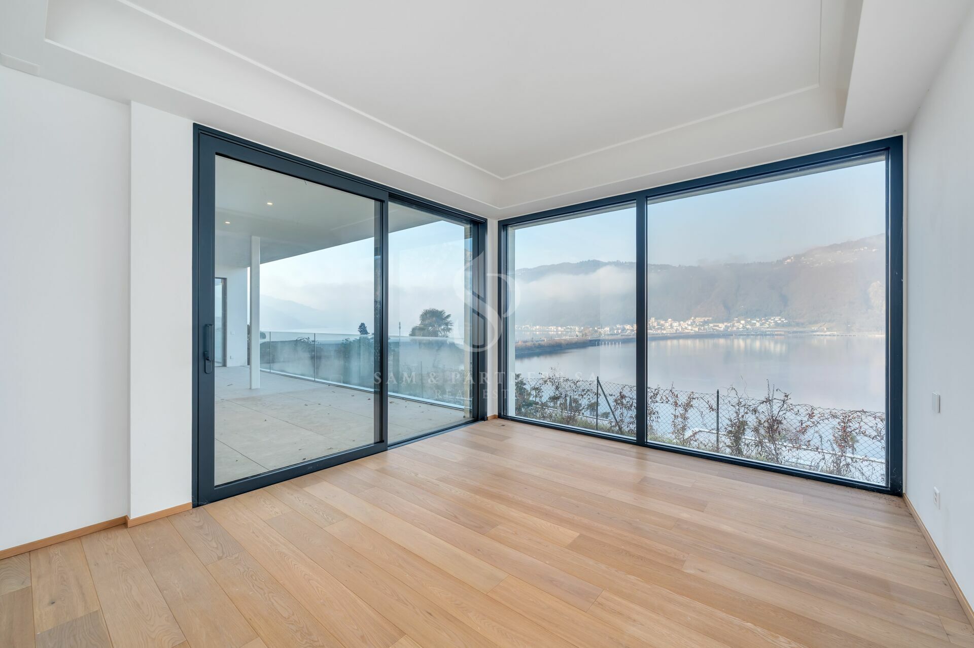 Heller Raum mit Panoramafenstern und Seeblick
