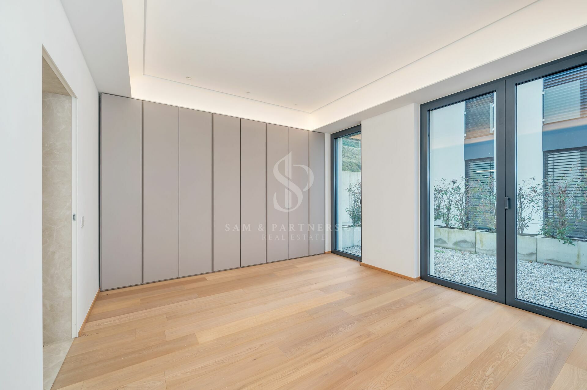 Helles, modernes Zimmer mit Einbauschrank und bodentiefen Fenstern