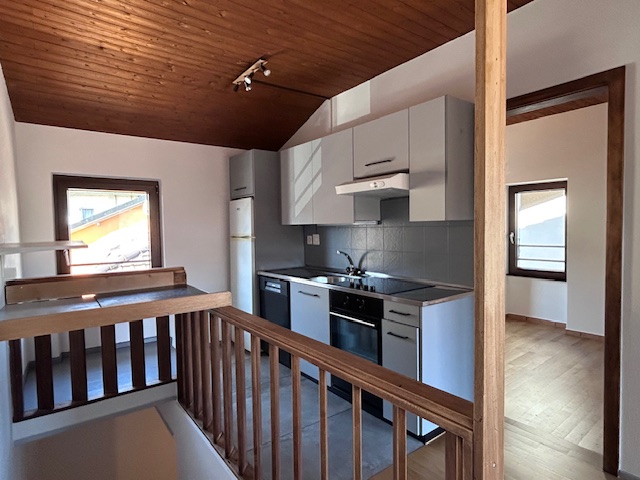 Offene Küche mit Galerie und Holzdecke