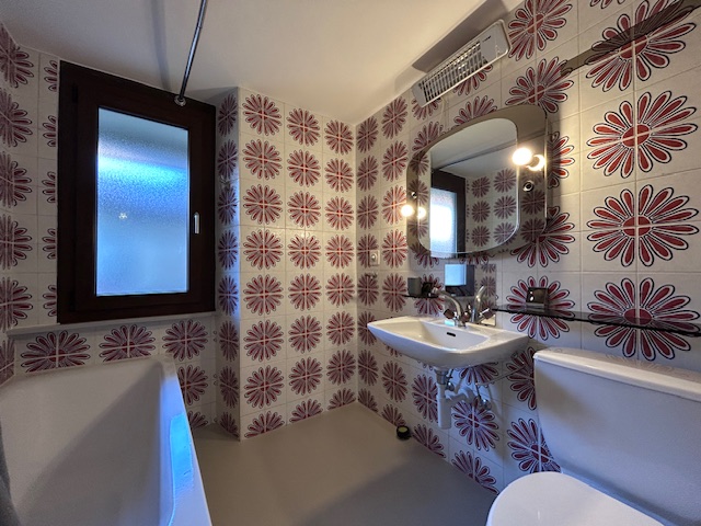 Bunt gemustertes Badezimmer mit Waschbecken und Toilette