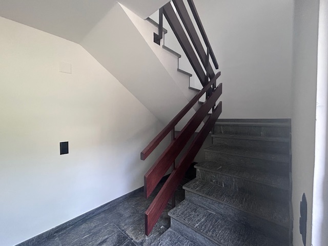 Treppenhaus mit dunklem Geländer