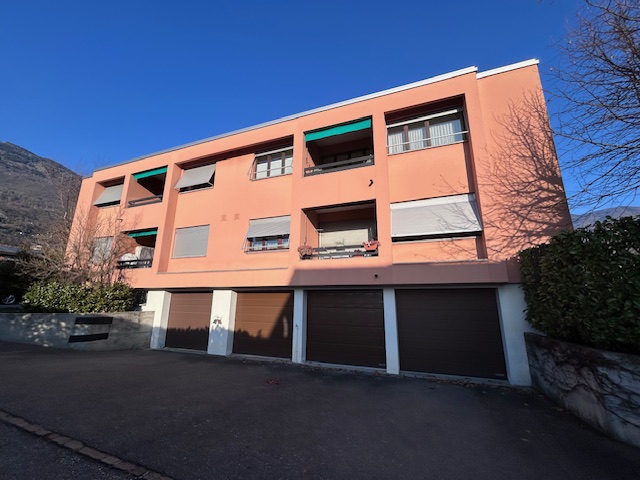 Mehrfamilienhaus mit verputzter Fassade und Garagen