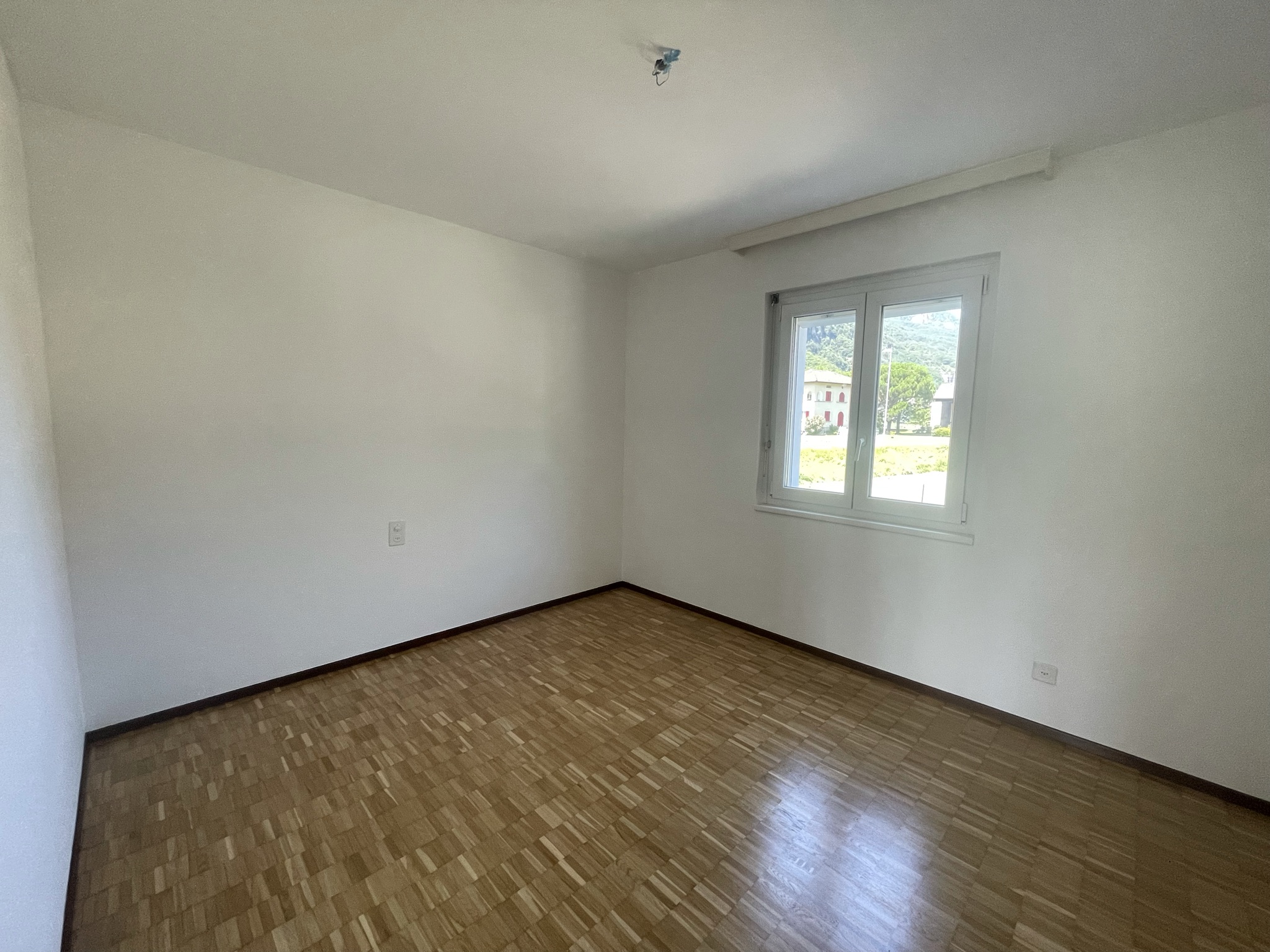 Leerer heller Raum mit Parkett und Fensterblick