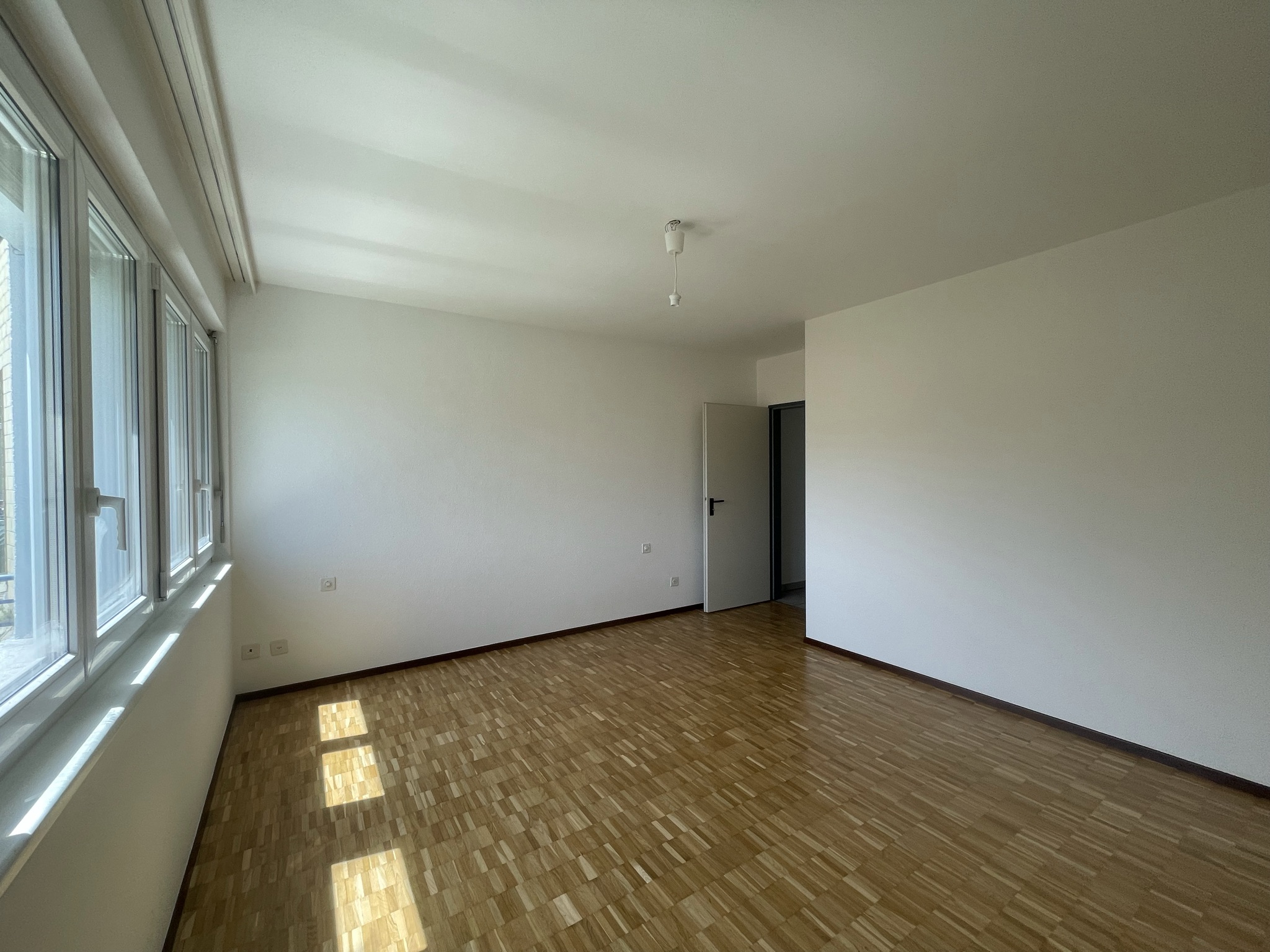 Leeres, helles Zimmer mit Parkettboden