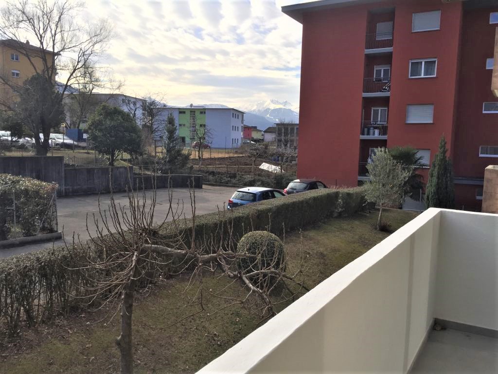 Balkon mit Blick auf Wohnanlage und Berge