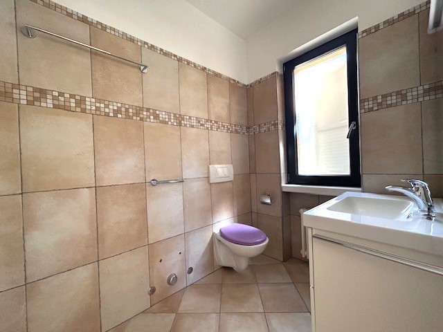 Badezimmer mit Fliesen und Fenster