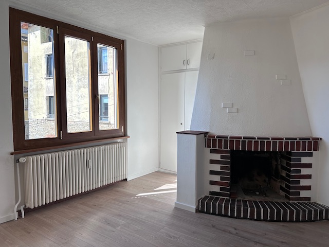 Wohnzimmer mit Kamin und großem Fenster