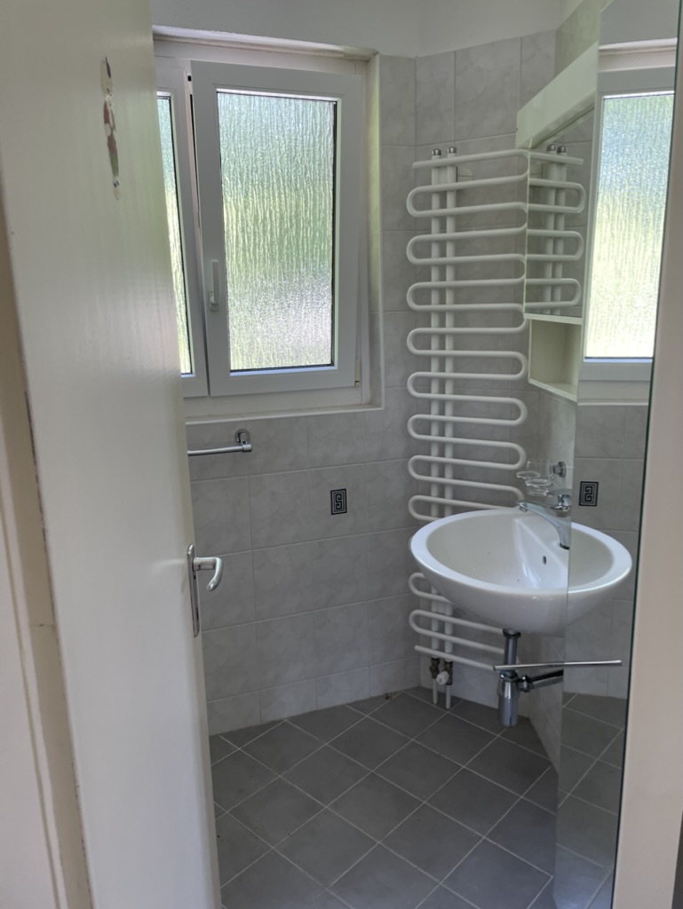 Kleines Badezimmer mit Fenster und Heizkörper