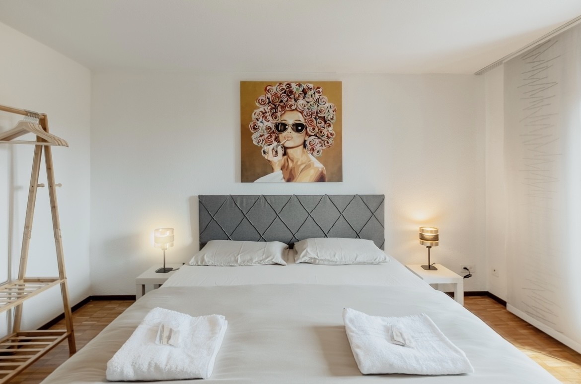 Helles Schlafzimmer mit Doppelbett und schlichter Einrichtung