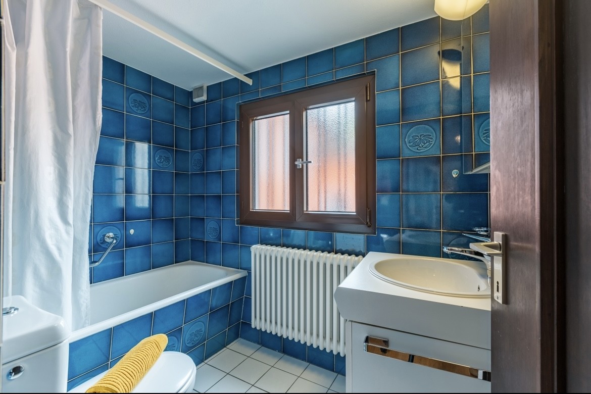 Badezimmer mit blauen Fliesen und Badewanne