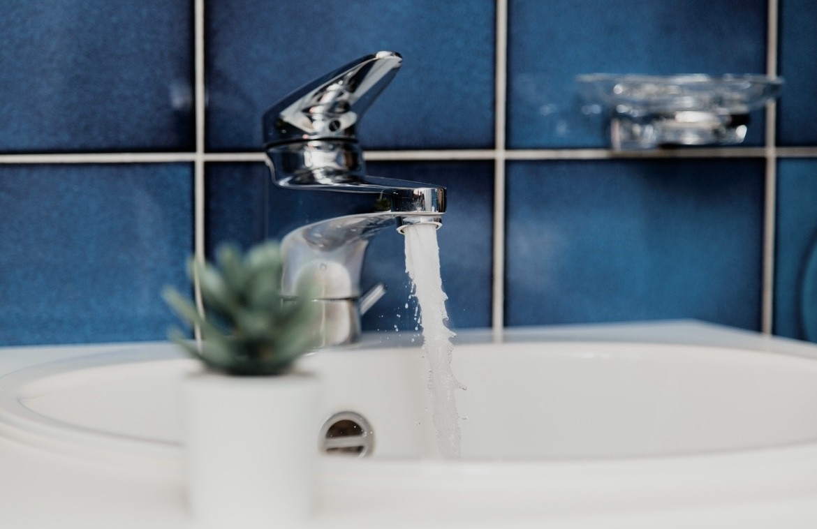 Badezimmer mit laufender Armatur