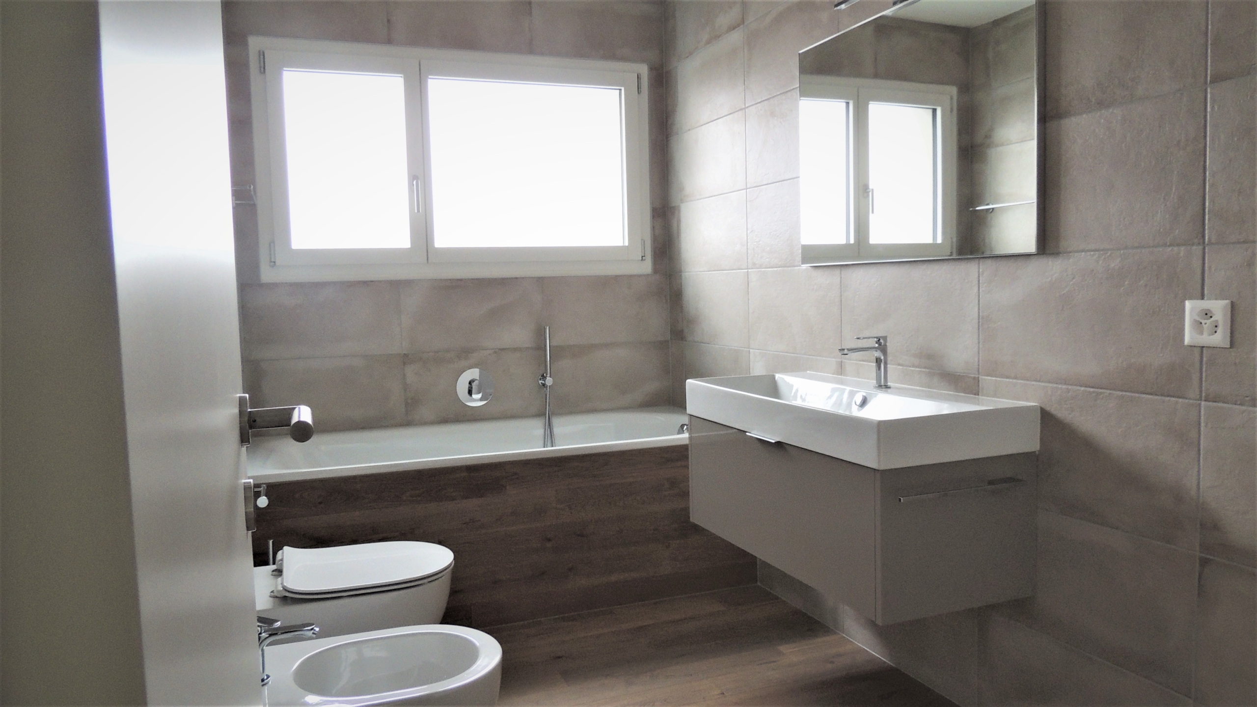 Modernes Badezimmer mit Badewanne, Waschtisch und WC