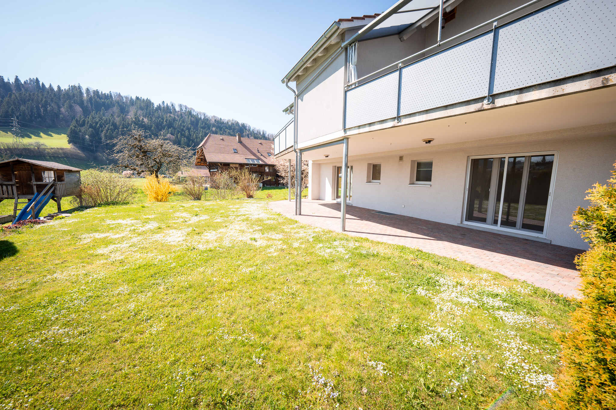 Außenansicht eines Wohnhauses mit Garten und Terrasse
