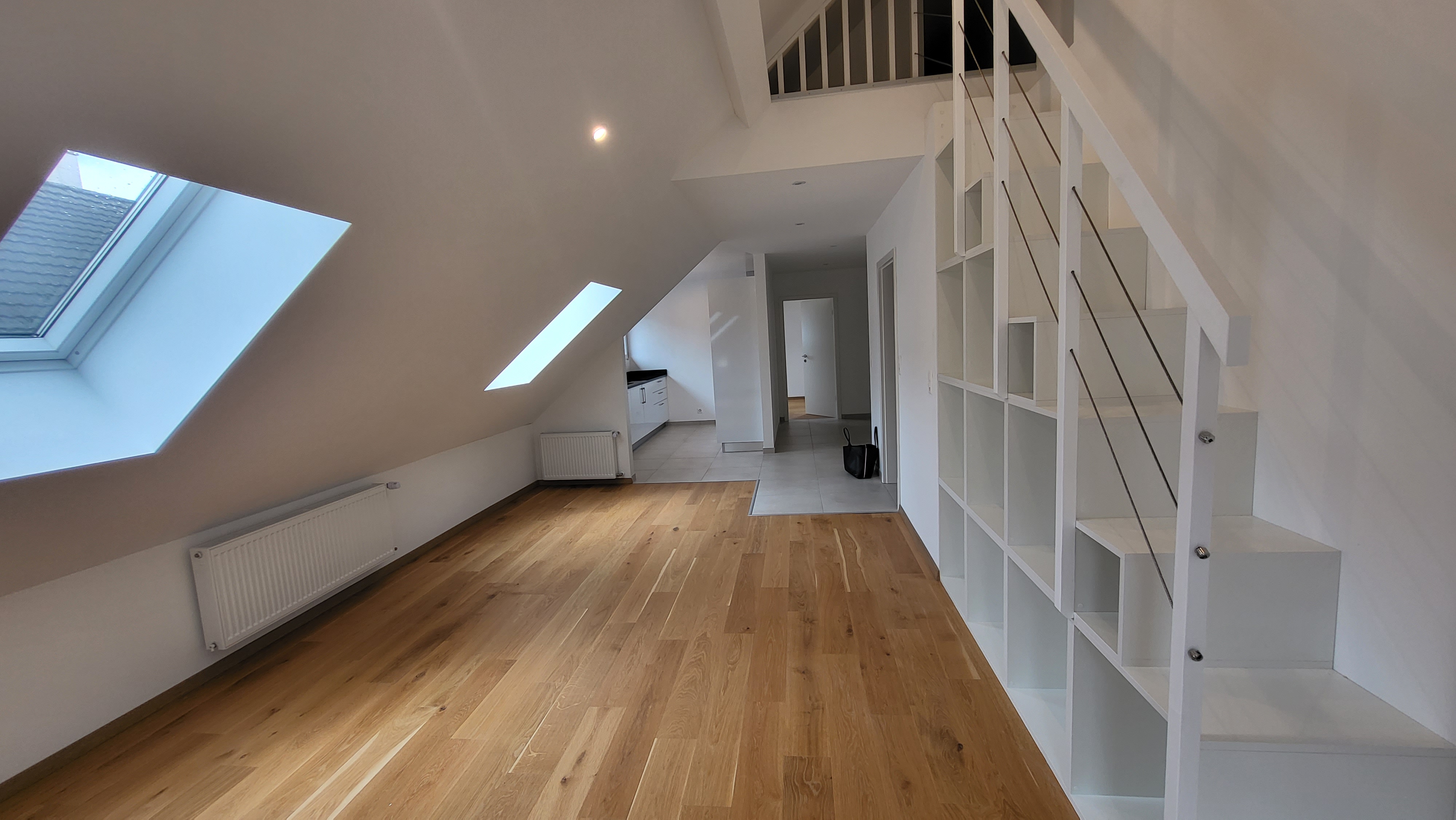 Heller Dachgeschossraum mit Galerie und Einbauregal