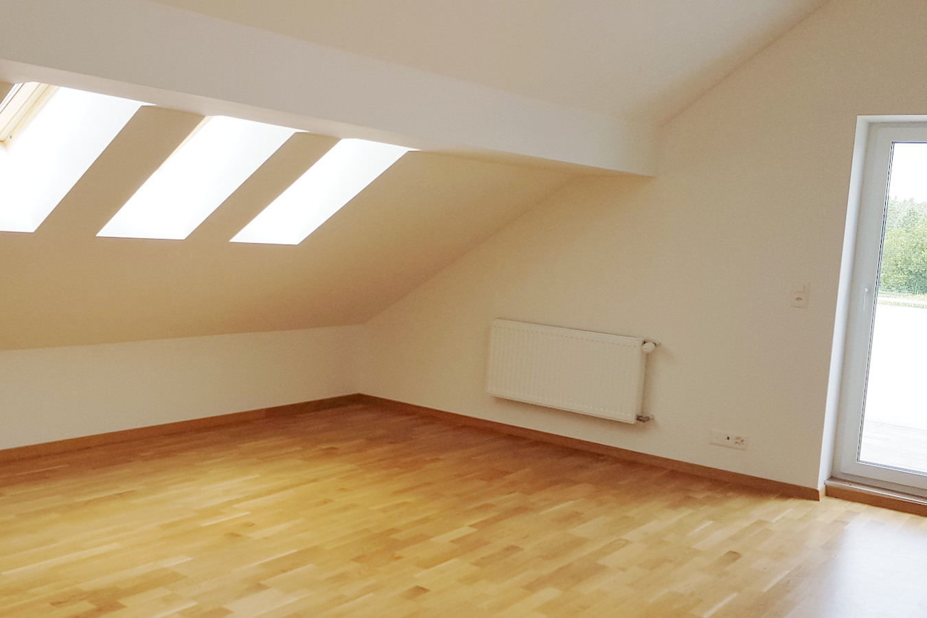 Heller Dachraum mit Holzboden und Dachfenstern