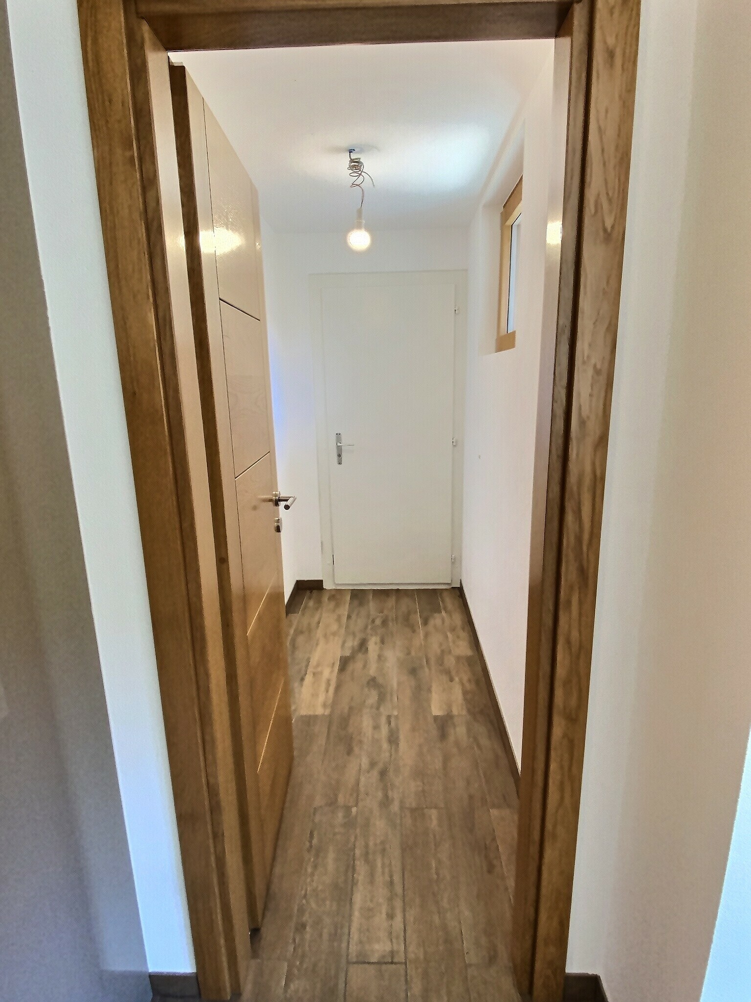 Flur mit Holztür und weißer Innentür