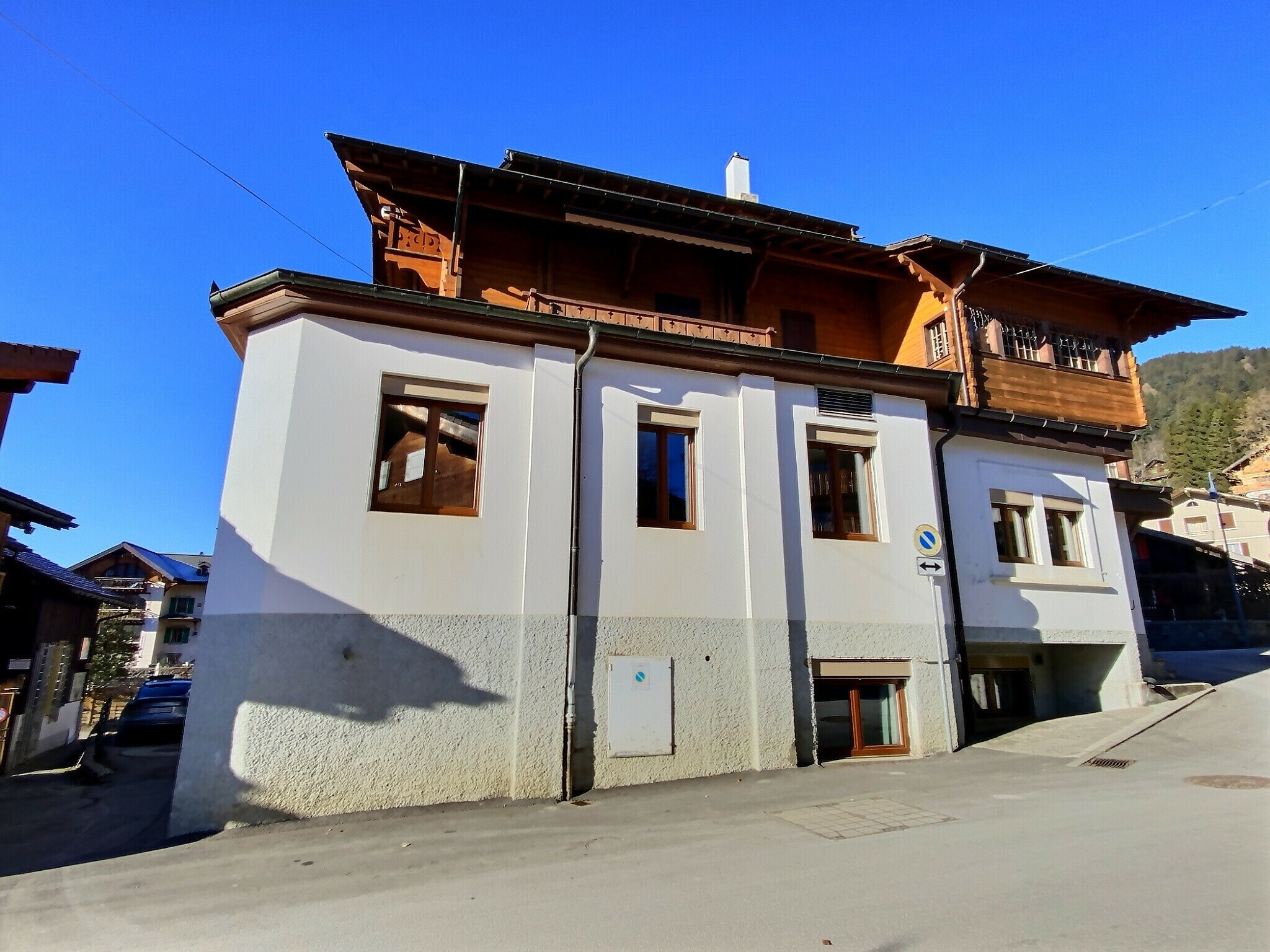 Alpenhaus mit weißem Sockel und Holzobergeschoss