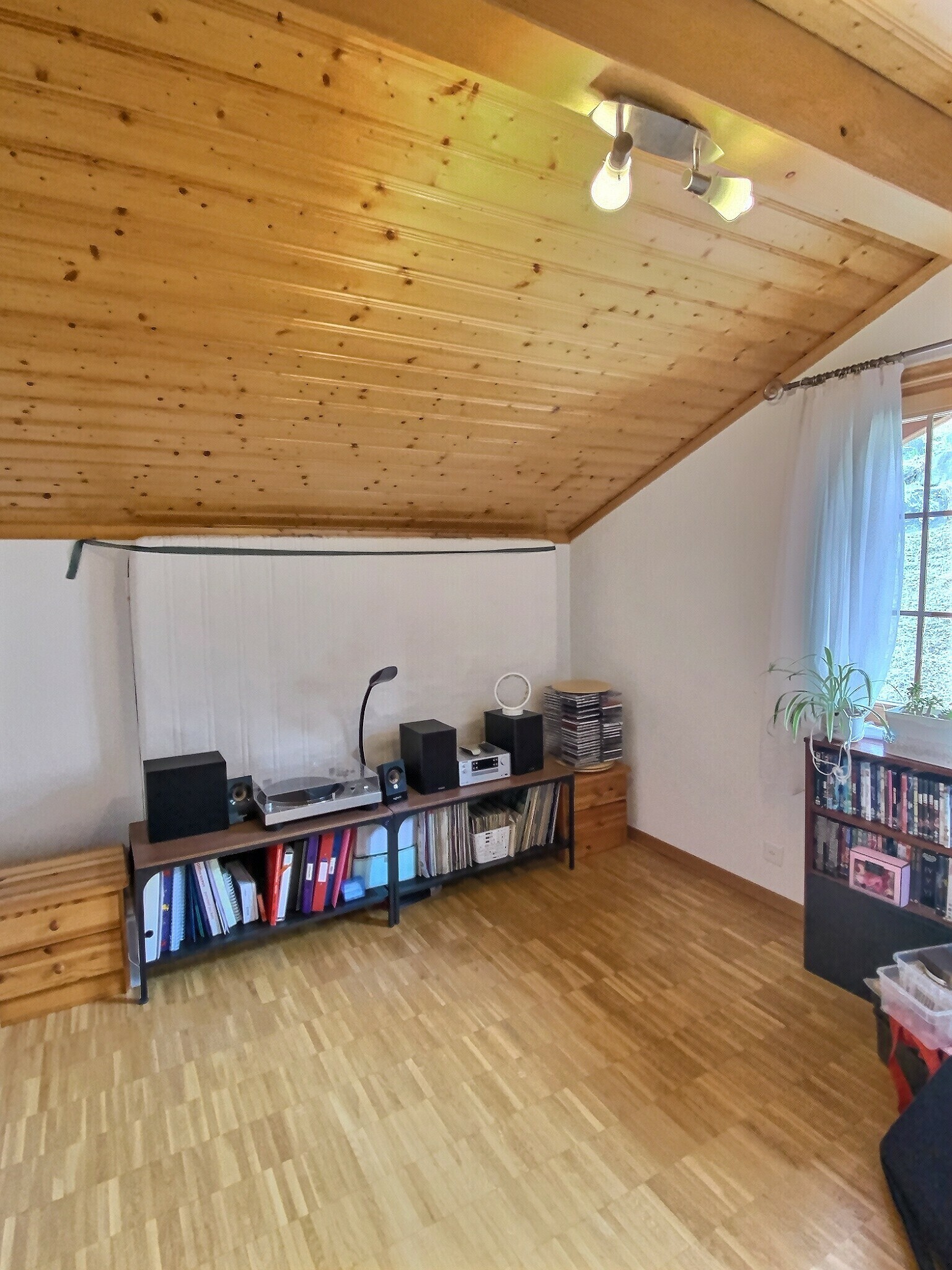 Dachzimmer mit Holzdecke und Musikbereich