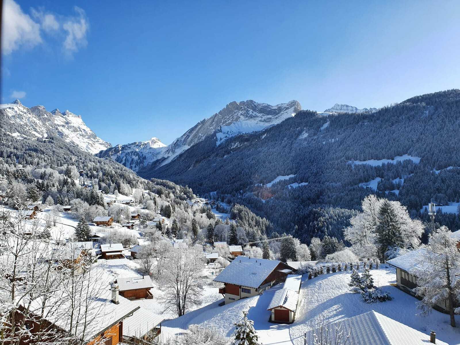 Verschneites Bergdorf mit Talblick