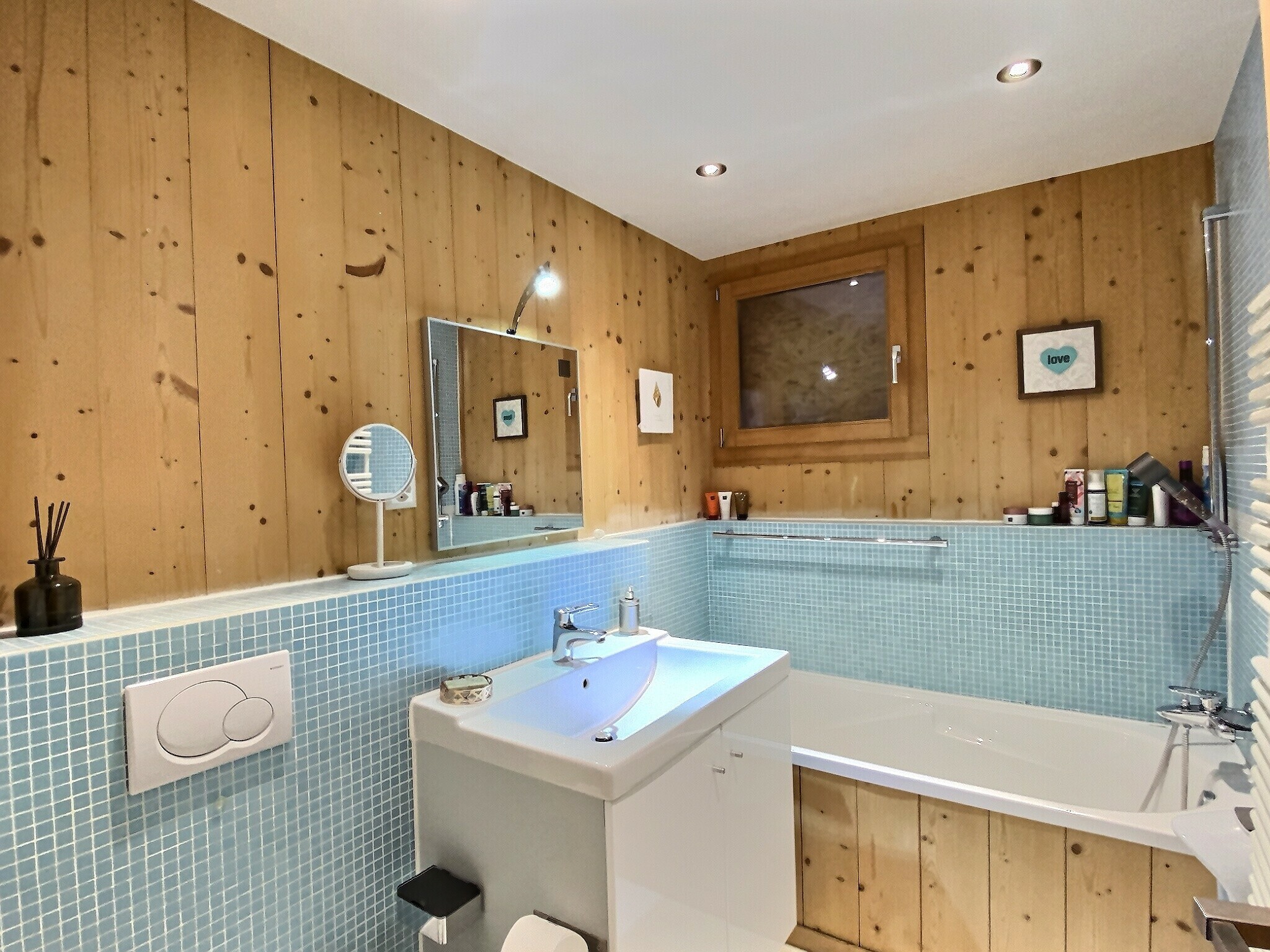 Badezimmer mit Holzverkleidung und blauem Mosaik