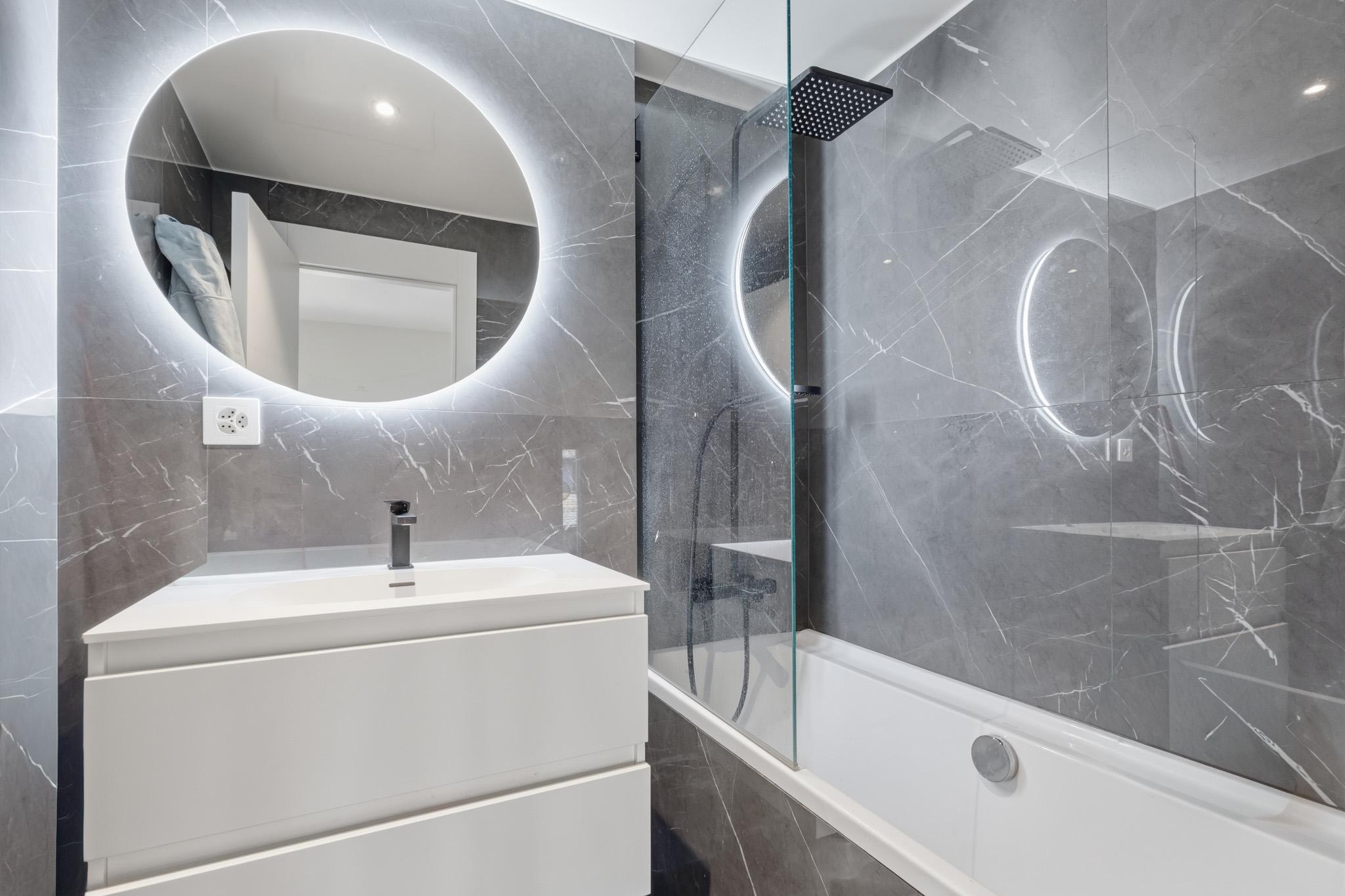 Modernes Badezimmer mit LED-Spiegel und Walk-in-Wanne