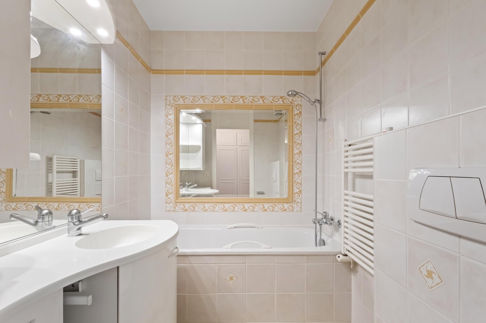 Helles Badezimmer mit Wanne und Spiegel