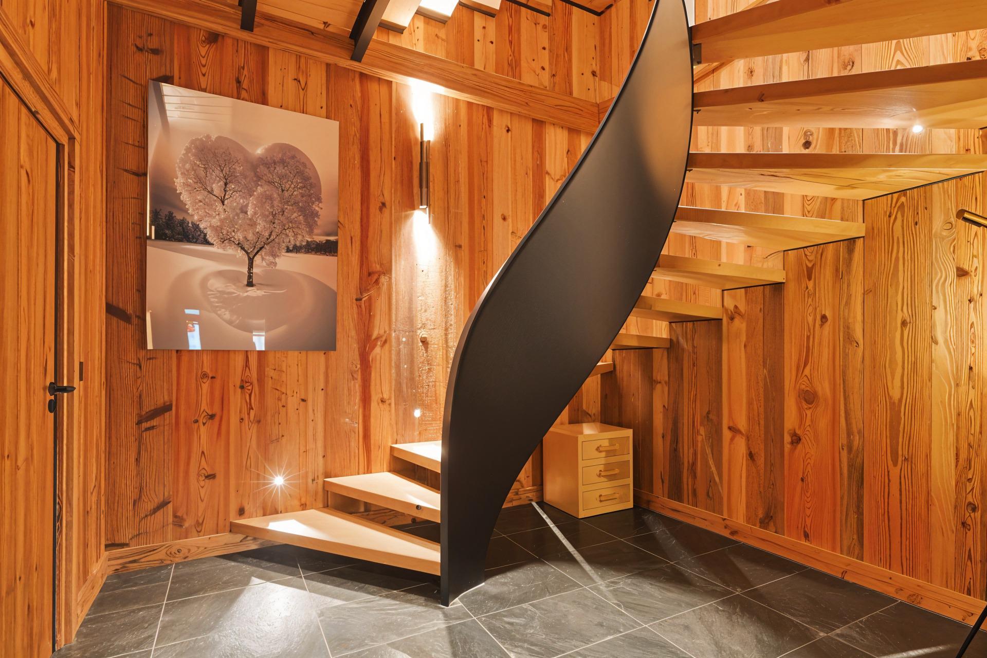 Holzverkleideter Treppenbereich mit schwarzer Spindeltreppe