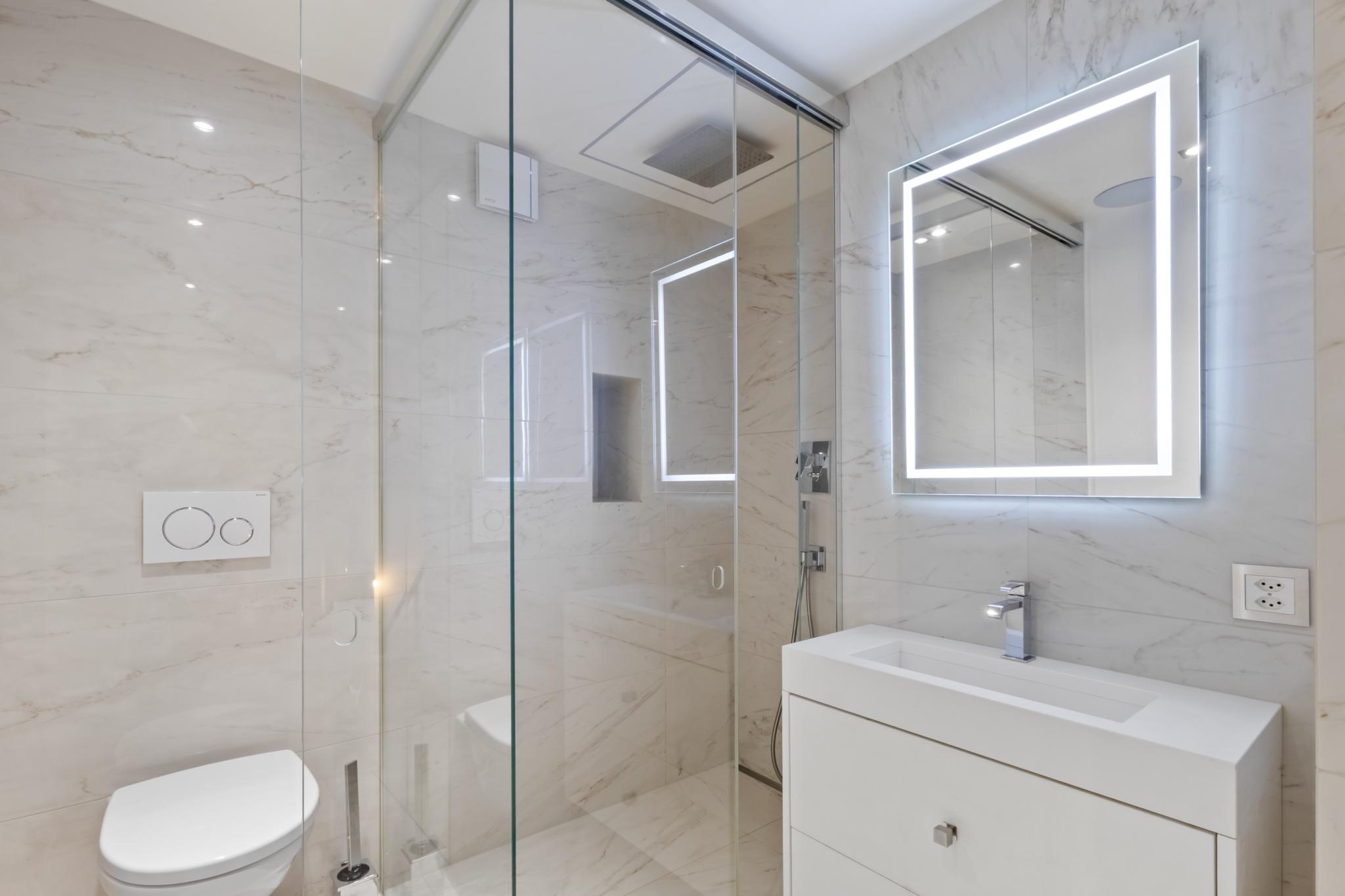 Modernes Badezimmer mit Glasdusche und LED-Spiegel