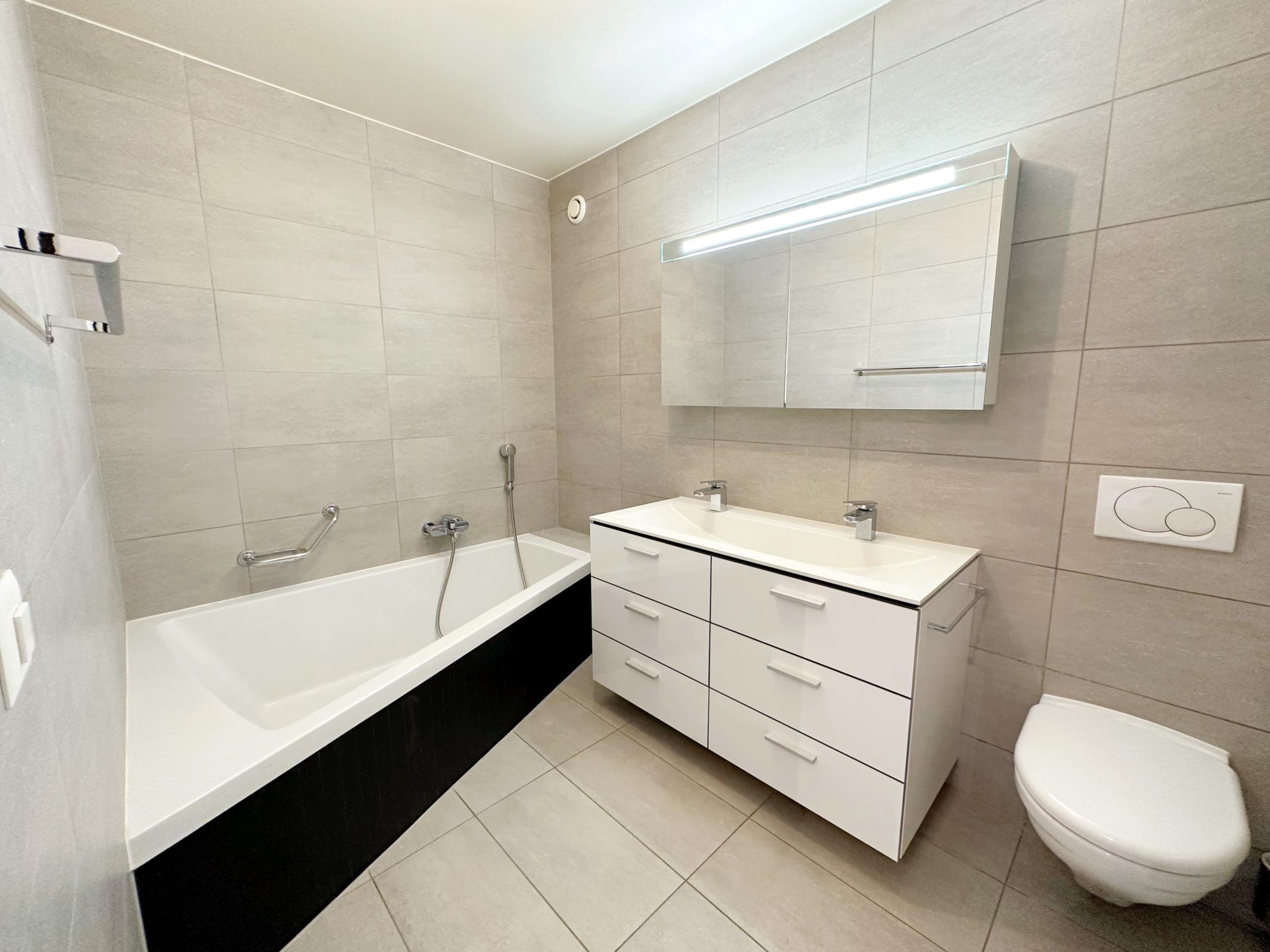 Modernes Badezimmer mit Wanne, Waschtisch und WC