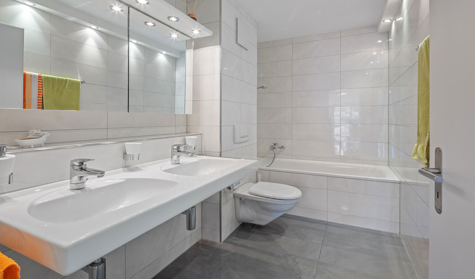 Helles, modernes Badezimmer mit Doppelwaschtisch und Badewanne
