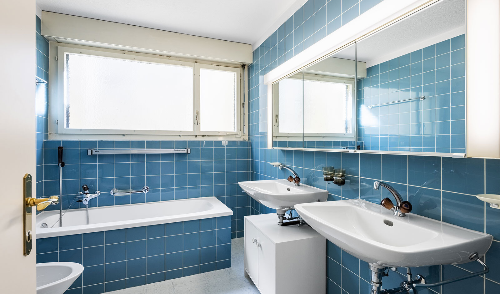 Badezimmer mit blauen Fliesen und Doppelwaschtisch