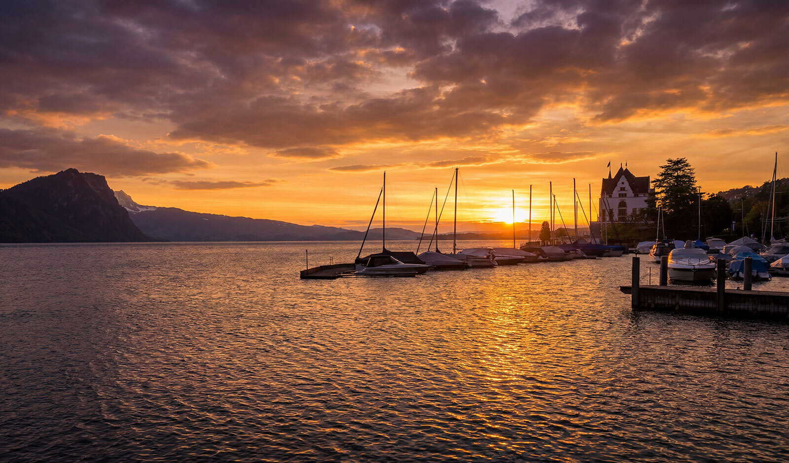 See mit Sonnenuntergang und Yachthafen