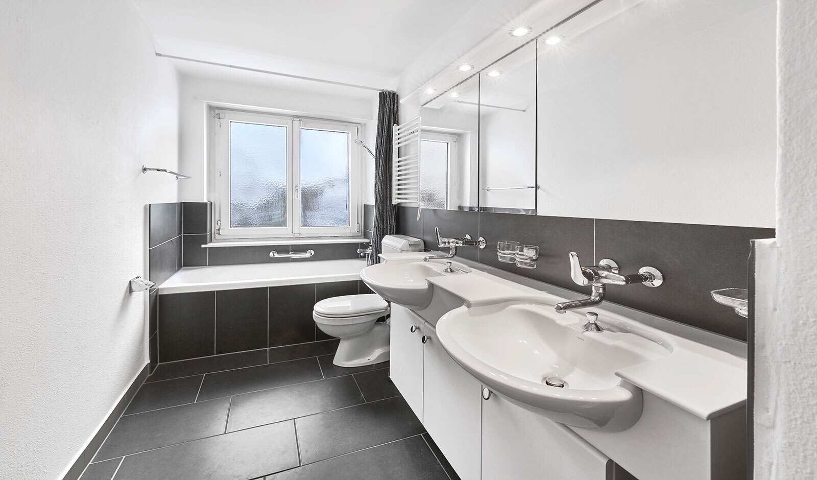 Modernes Badezimmer mit Doppelwaschtisch und Badewanne