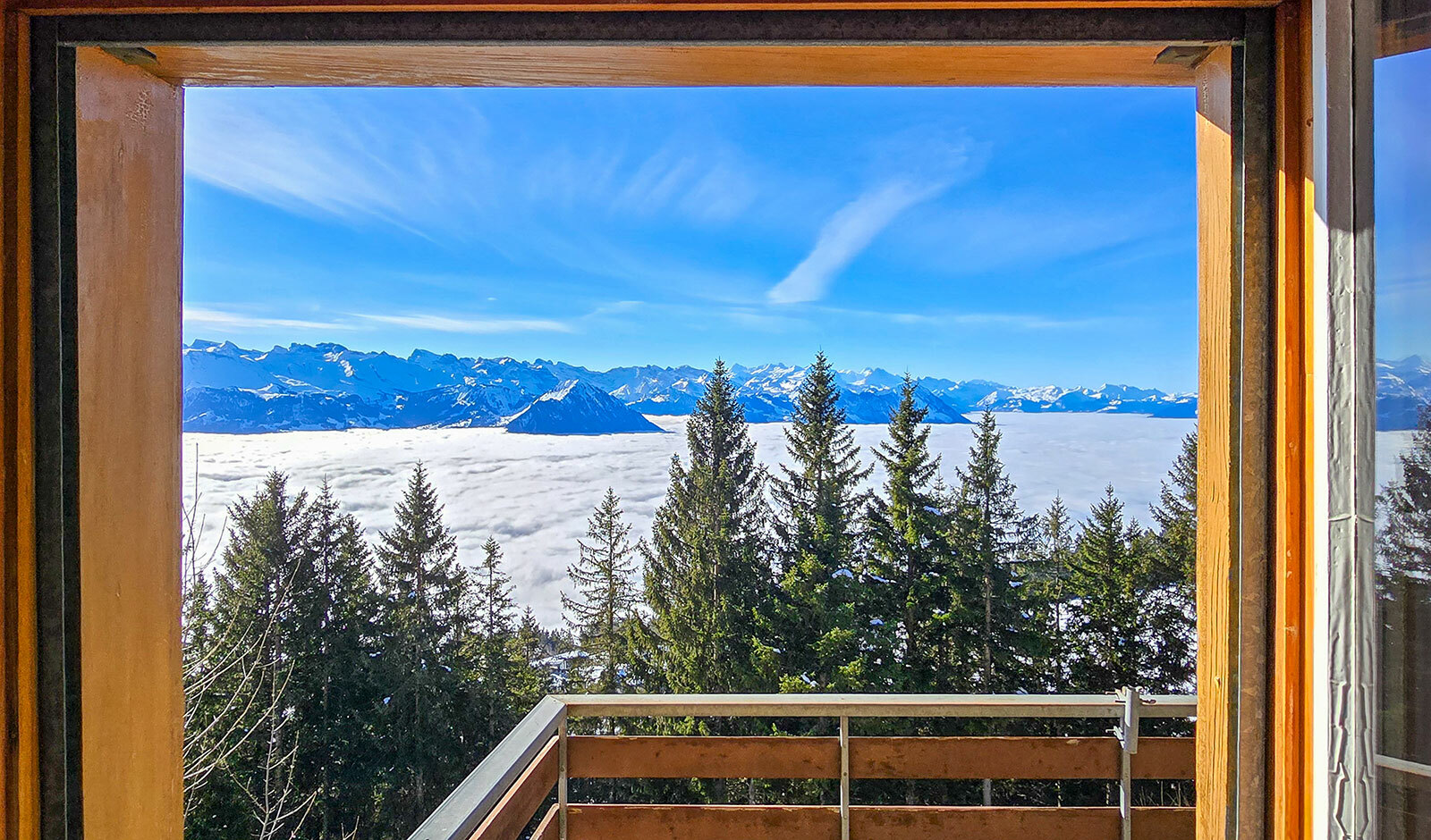 Bergblick durch ein Fenster mit Balkon